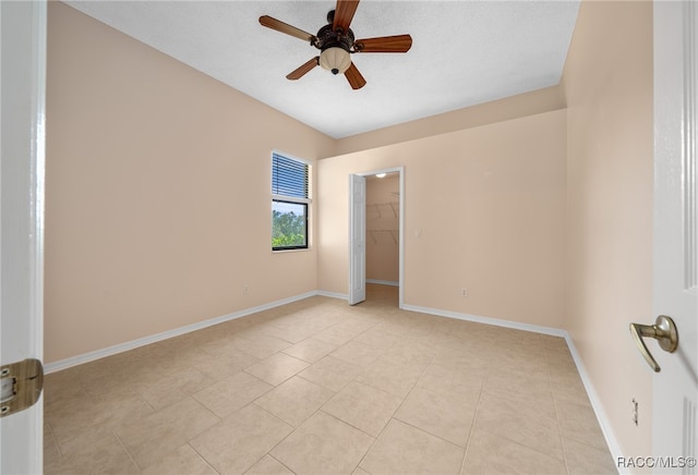 unfurnished room with light tile patterned floors, a textured ceiling, and ceiling fan