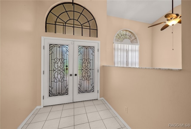 tiled entryway with ceiling fan, lofted ceiling, and french doors