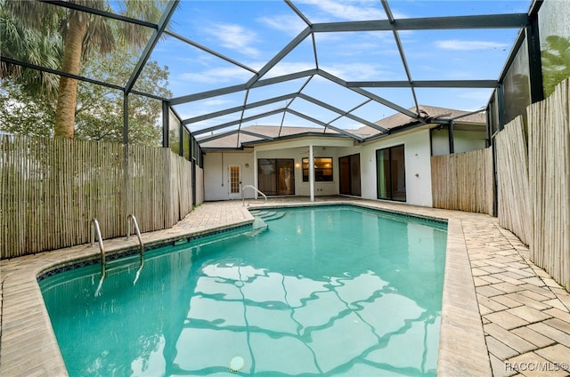 view of swimming pool featuring glass enclosure and a patio area