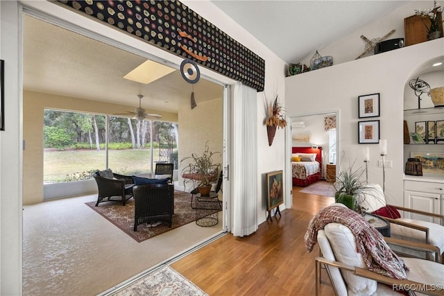 interior space featuring wood-type flooring, high vaulted ceiling, ceiling fan, and a skylight