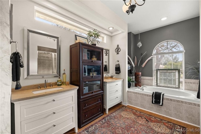 bathroom with vanity, wood-type flooring, and plus walk in shower