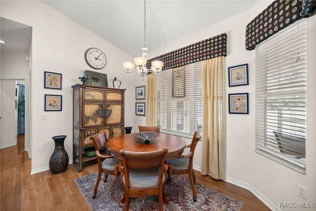 dining room with wood-type flooring, vaulted ceiling, and plenty of natural light