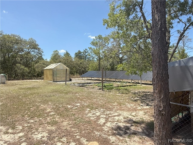 view of yard with an outbuilding and a greenhouse