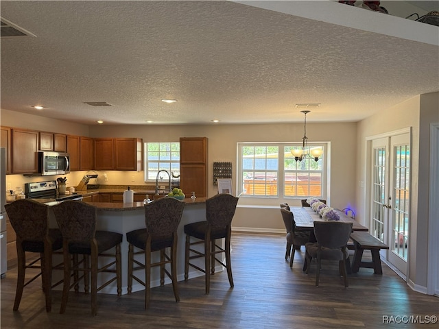 kitchen with recessed lighting, dark wood finished floors, a kitchen bar, and stainless steel appliances