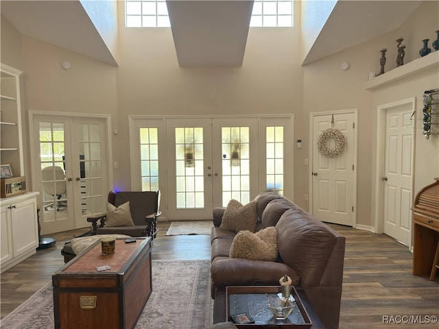 living area featuring french doors, dark wood-style floors, and a towering ceiling