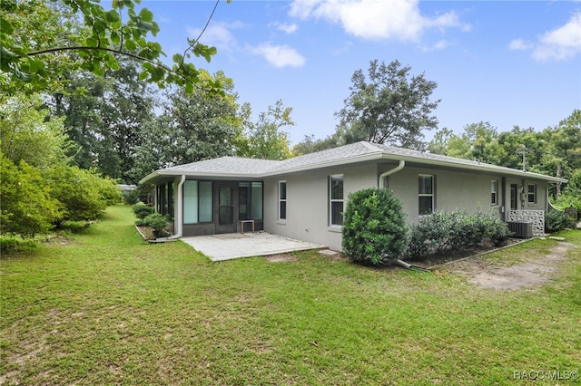 rear view of property with a lawn, central AC unit, and a patio