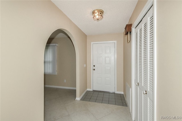 tiled foyer with a textured ceiling