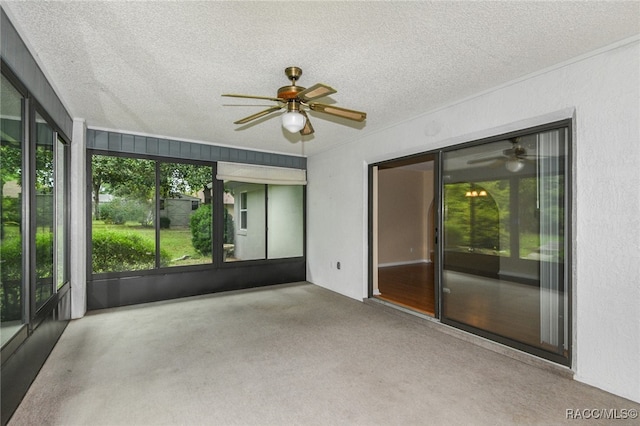 unfurnished sunroom featuring ceiling fan