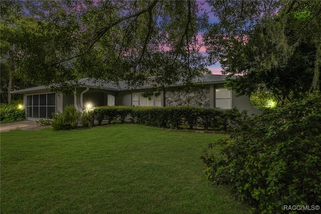 view of front of home featuring a lawn and a sunroom