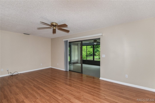 spare room featuring a textured ceiling and hardwood / wood-style flooring