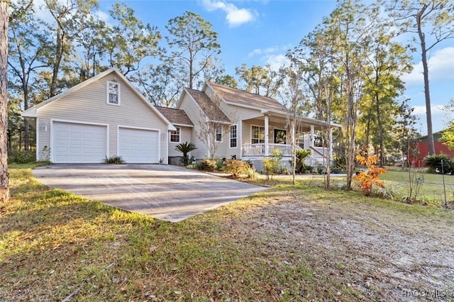 view of front of home featuring a garage, covered porch, and a front yard