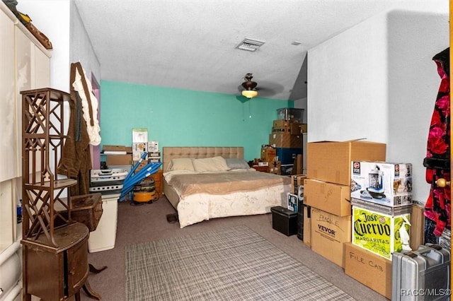 bedroom with a textured ceiling, carpet floors, ceiling fan, and visible vents