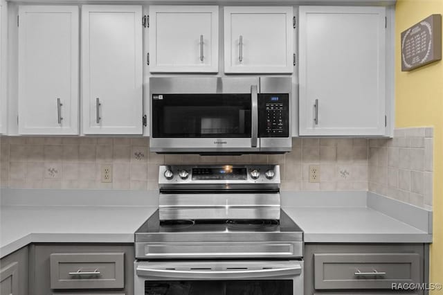 kitchen featuring stainless steel appliances, light countertops, and gray cabinetry