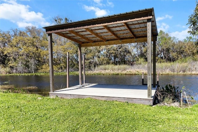 view of dock with a yard and a water view