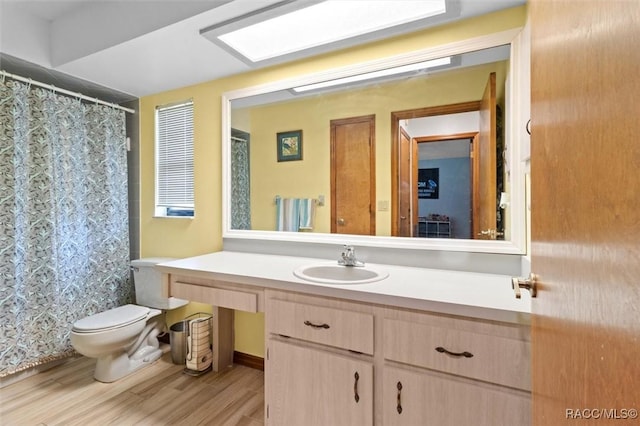 full bath featuring vanity, curtained shower, wood finished floors, and toilet