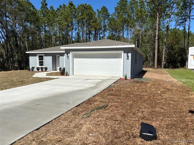 ranch-style house with a shingled roof, concrete driveway, a garage, and stucco siding