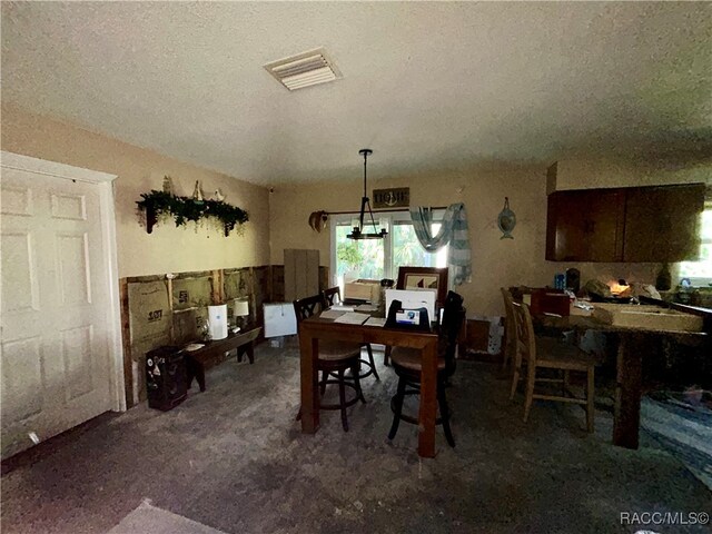 dining space featuring carpet flooring and a textured ceiling