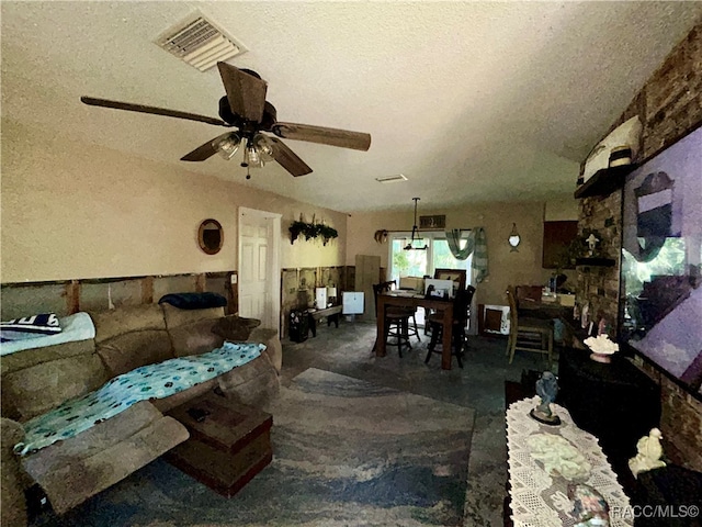 living room featuring a textured ceiling and ceiling fan