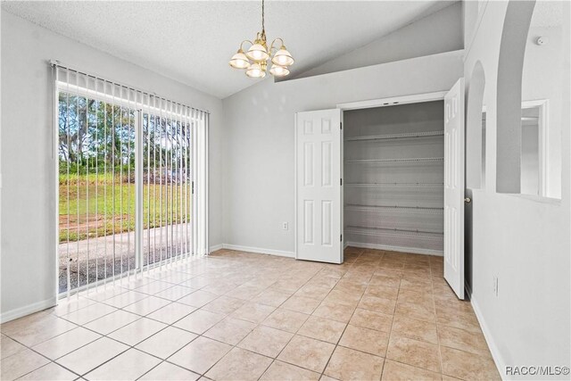3143 Grayton Dr, Spring Hill, FL 34609 - unfurnished dining area featuring a chandelier, vaulted ceiling, light tile patterned flooring, and arched walkways
