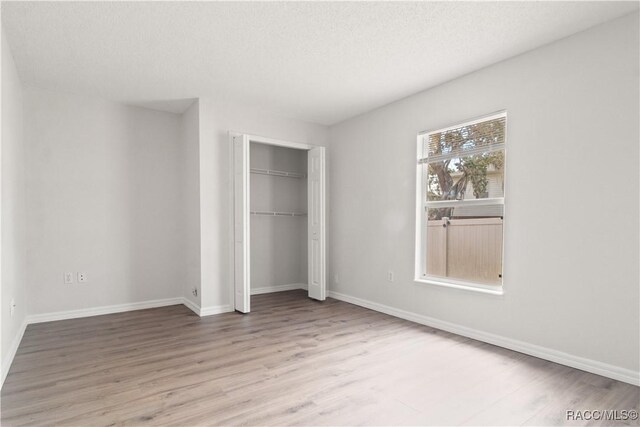 3143 Grayton Dr, Spring Hill, FL 34609 - unfurnished bedroom with wood finished floors and a closet