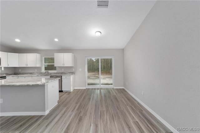 kitchen featuring visible vents, baseboards, white cabinetry, light stone countertops, and dishwasher