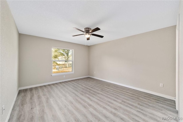 empty room featuring ceiling fan, a textured ceiling, wood finished floors, and baseboards