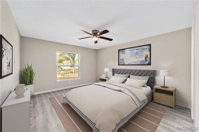 bedroom with baseboards, ceiling fan, and light wood-style floors