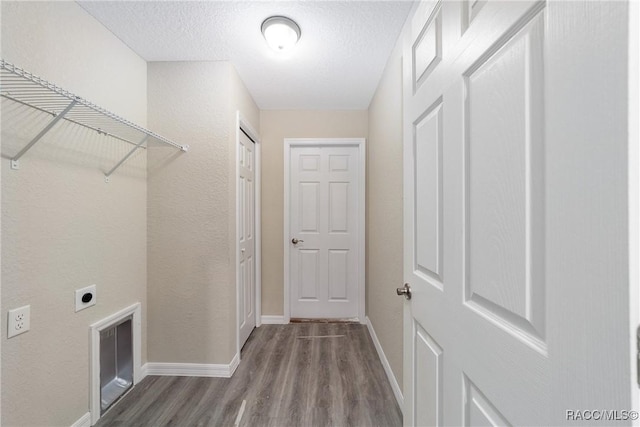 washroom with electric dryer hookup, a textured ceiling, wood finished floors, laundry area, and baseboards