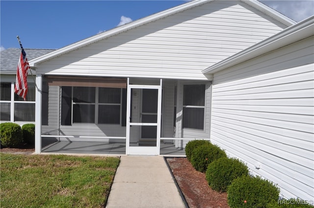 view of exterior entry with a yard