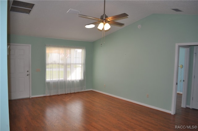 empty room with ceiling fan, dark hardwood / wood-style floors, and vaulted ceiling