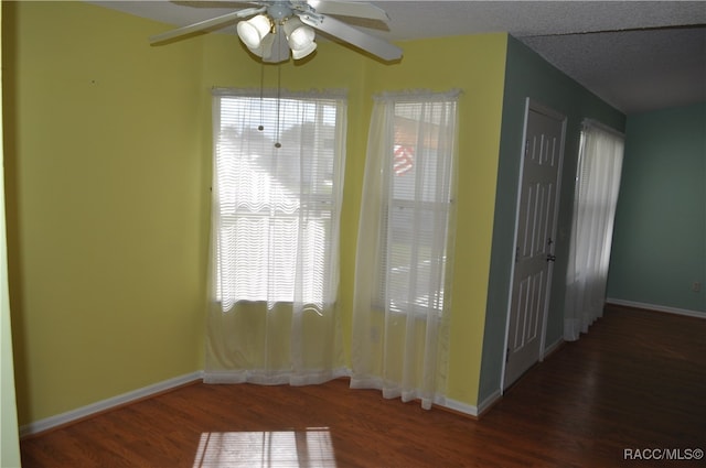 interior space with ceiling fan, dark hardwood / wood-style flooring, and a textured ceiling