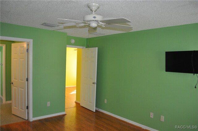 unfurnished bedroom with hardwood / wood-style floors, a textured ceiling, and ceiling fan