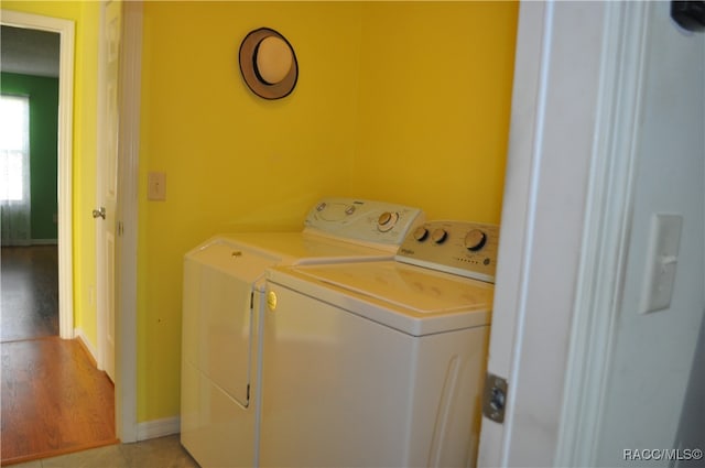 laundry room with washer and dryer and light hardwood / wood-style floors