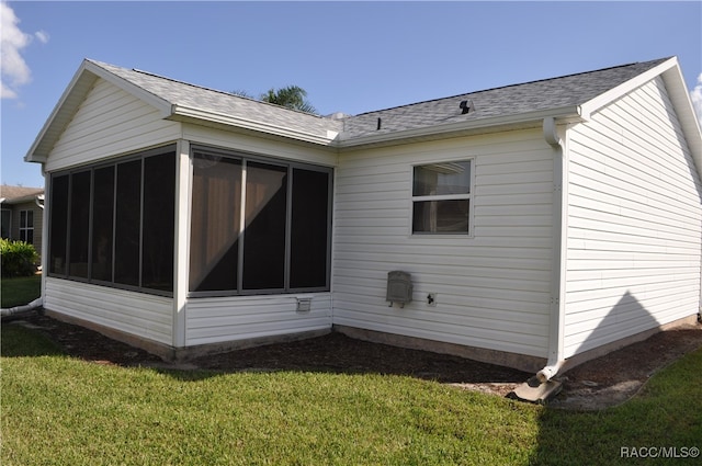 view of property exterior featuring a sunroom and a yard