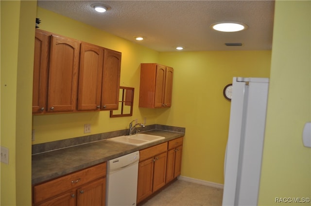 kitchen featuring a textured ceiling, white dishwasher, and sink