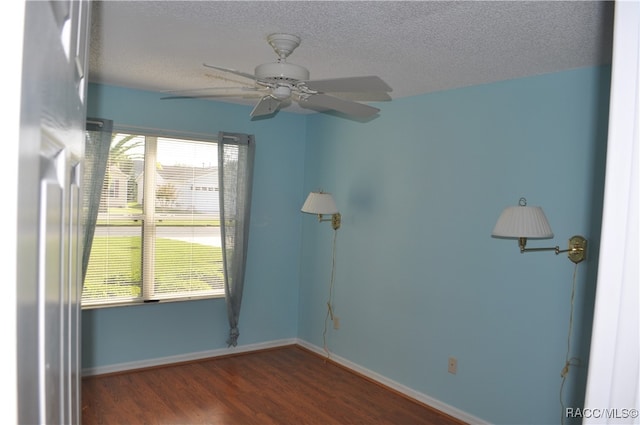 unfurnished room with ceiling fan, dark wood-type flooring, and a textured ceiling