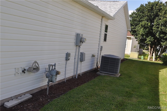 view of side of property featuring a yard and central air condition unit