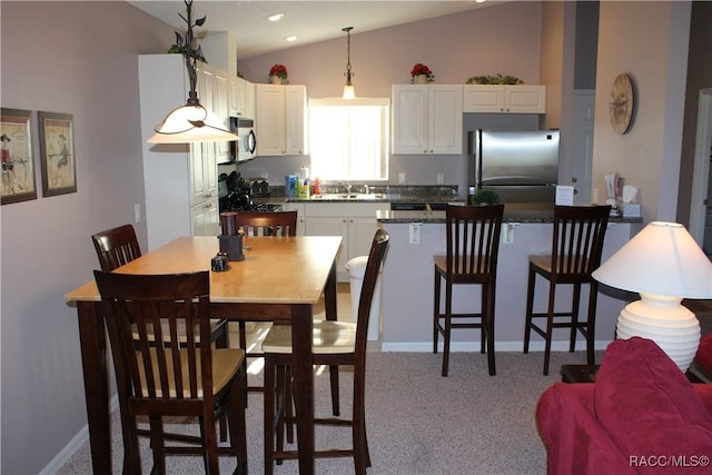 dining area featuring lofted ceiling, carpet floors, and baseboards