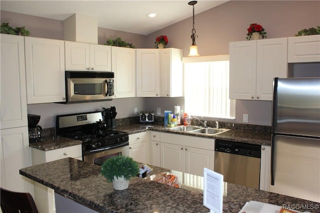 kitchen featuring stainless steel appliances, pendant lighting, white cabinetry, and a sink