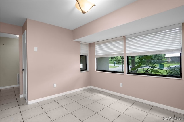 empty room with light tile patterned floors and plenty of natural light