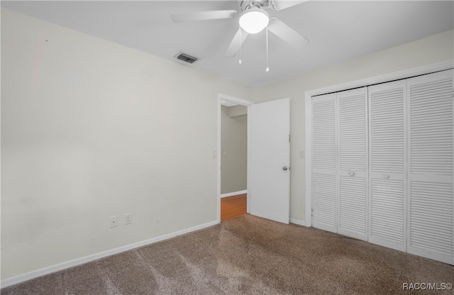 unfurnished bedroom with carpet, ceiling fan, and a closet