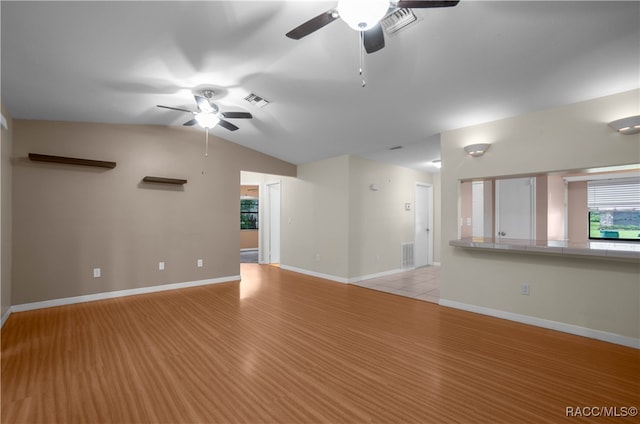 unfurnished living room featuring light wood-type flooring, vaulted ceiling, and ceiling fan