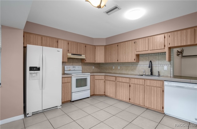 kitchen featuring light brown cabinetry, decorative backsplash, sink, and white appliances