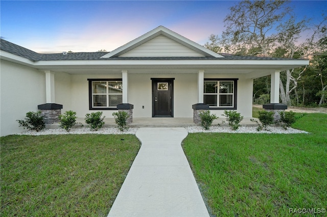 view of front of property featuring a lawn and a porch