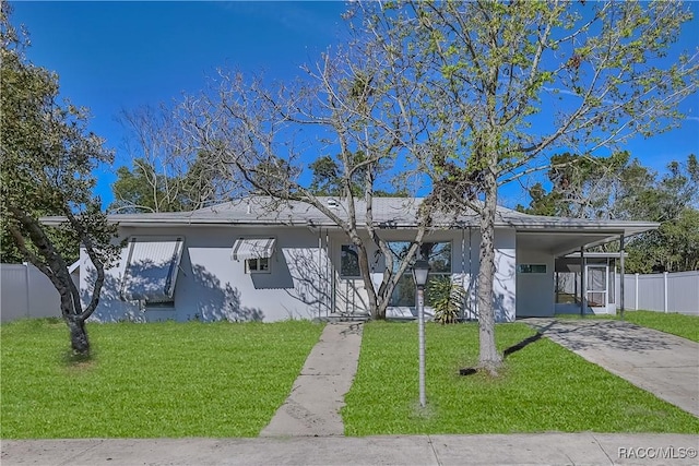 ranch-style home featuring stucco siding, an attached carport, concrete driveway, and a front yard