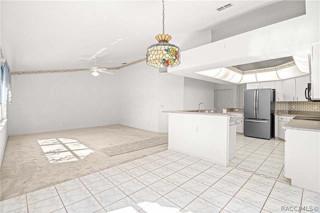 kitchen with ceiling fan, hanging light fixtures, stainless steel appliances, light carpet, and white cabinets