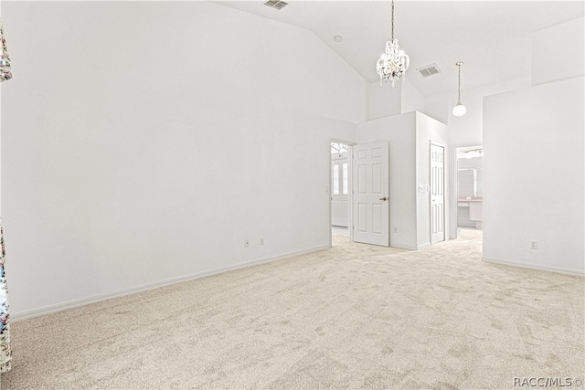 unfurnished room featuring high vaulted ceiling, light colored carpet, and a notable chandelier