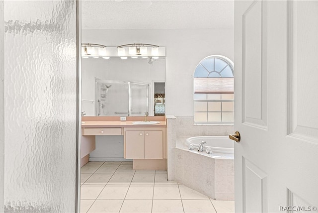 bathroom featuring vanity, shower with separate bathtub, a textured ceiling, and tile patterned floors