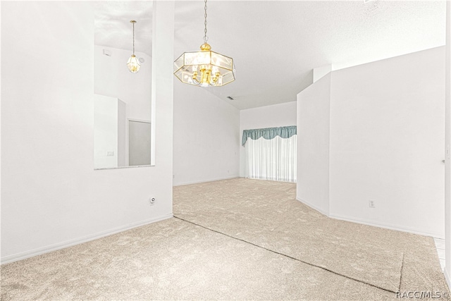 carpeted spare room with a notable chandelier, a textured ceiling, and vaulted ceiling