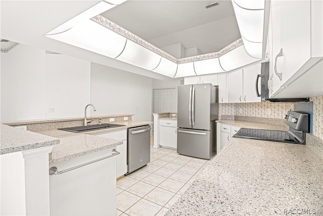 kitchen with white cabinetry, sink, stainless steel appliances, tasteful backsplash, and light tile patterned floors